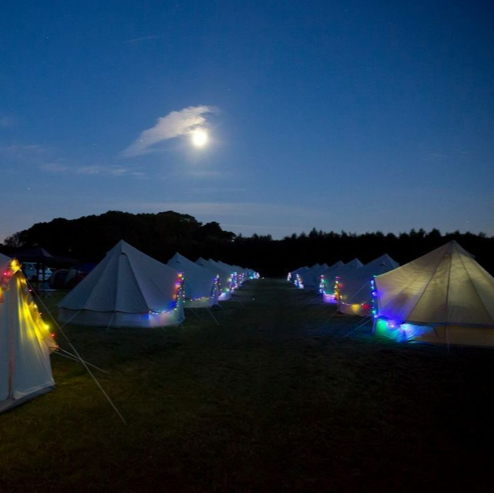 Solar powered coloured fairy lights on bell tent village